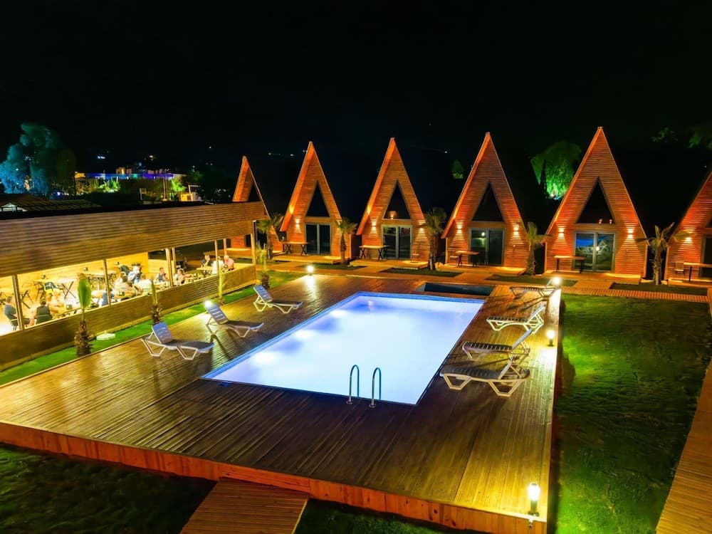 Araz Wooden Concept havuzu, restoranı ve bungalovlarının gece görünümü